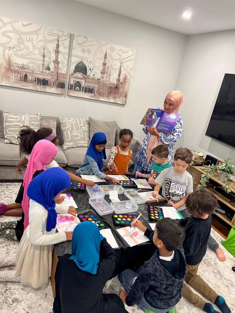 A teacher reading a storybook while children paint